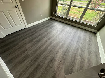 Bright room with newly installed grey vinyl plank flooring and painted walls
