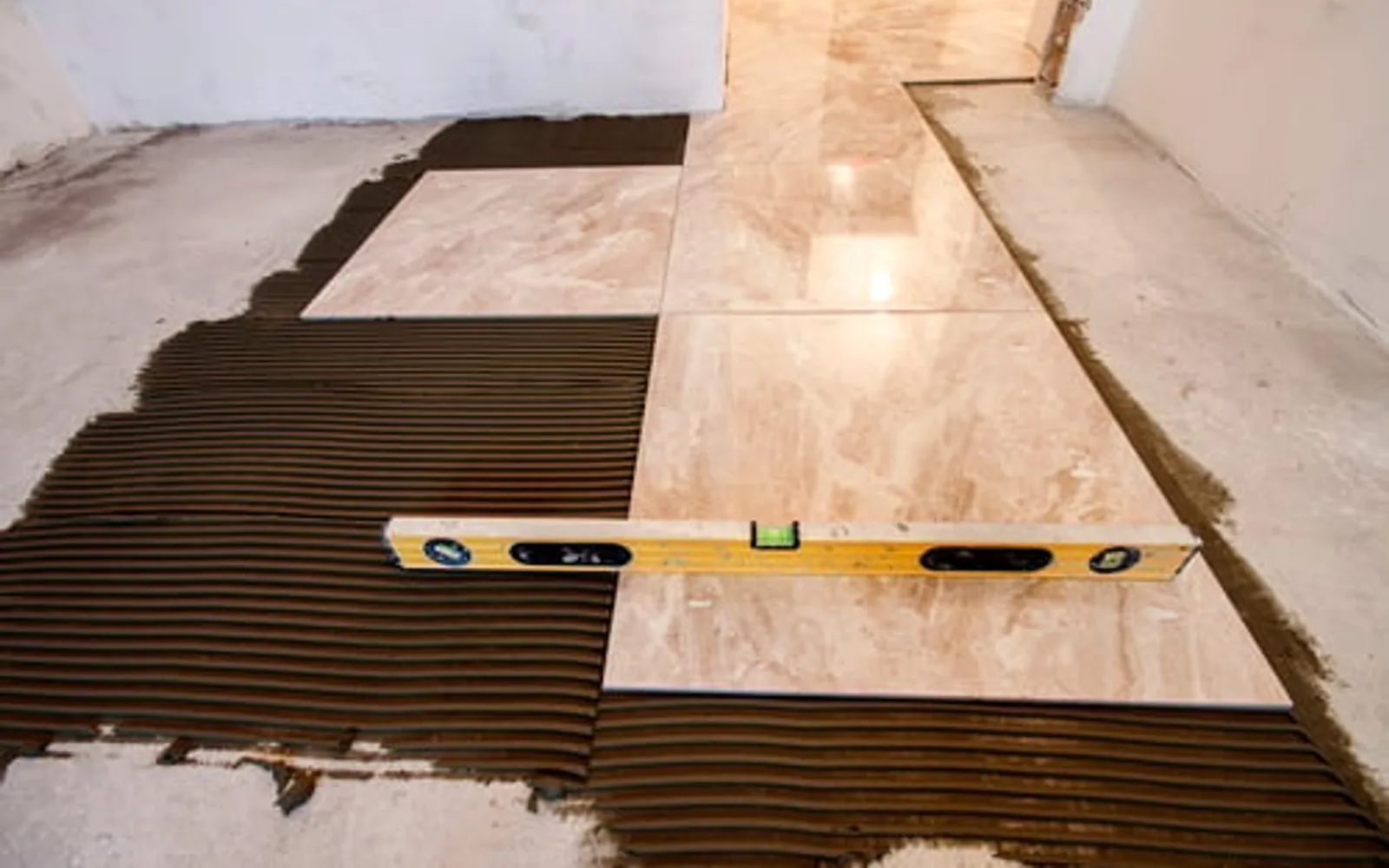 Wood-look flooring planks being installed over a prepared and troweled subfloor