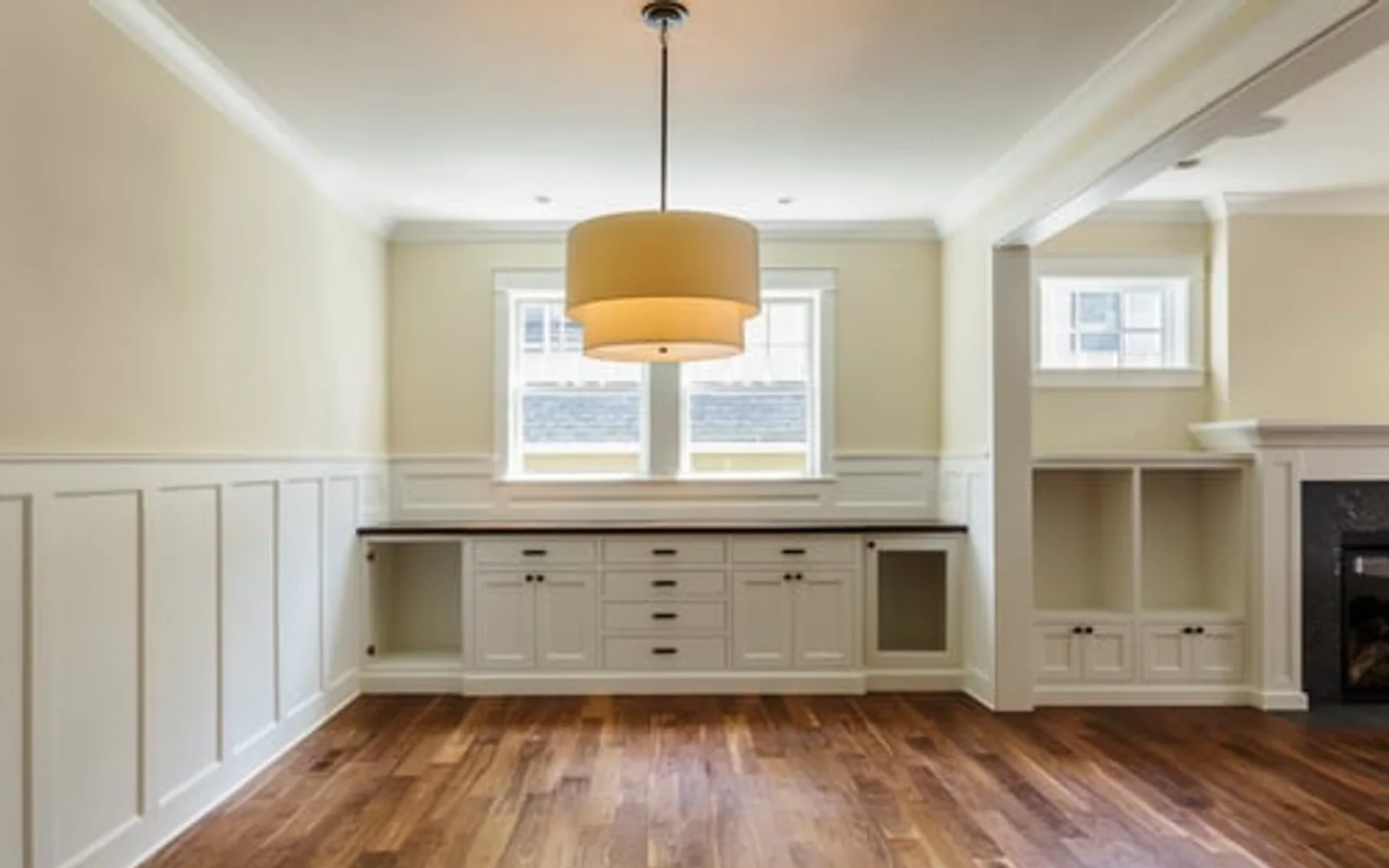 Finished interior carpentry with custom built-ins, wainscoting and crown molding in a bright living room